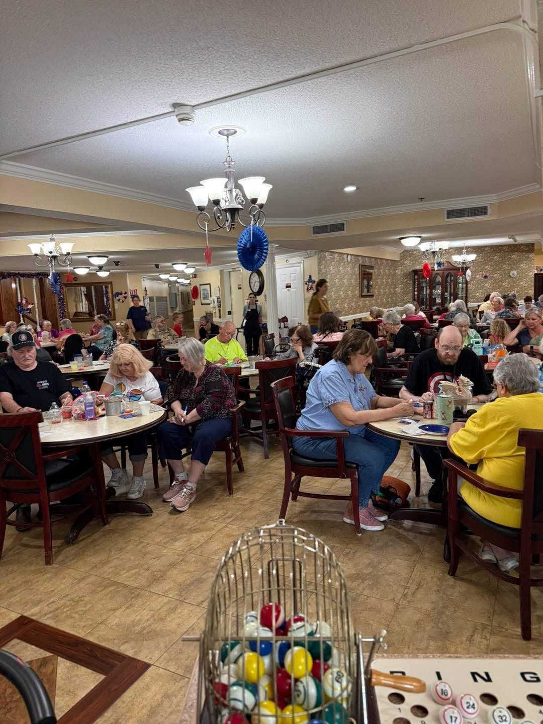 Bingo in the Autumn Ridge dining room, with the cage of balls in the foreground and residents at tables behind