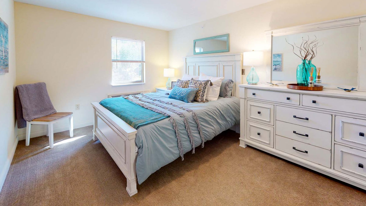 A furnished bedroom in an Autumn Ridge apartment, made up and ready