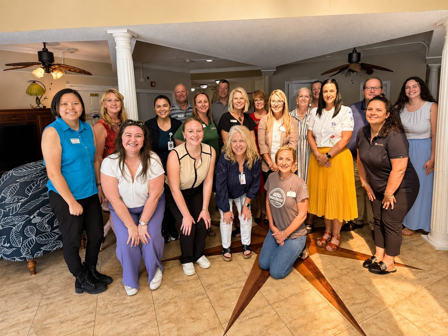 Autumn Ridge associates gathered in the lobby around the compass-rose floor inlay